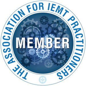 A circular badge with blue gears in the centre and “MEMBER” in bold white letters. The outer ring reads “THE ASSOCIATION FOR IEMT PRACTITIONERS” in blue, highlighting expertise in addressing trauma and PTSD.