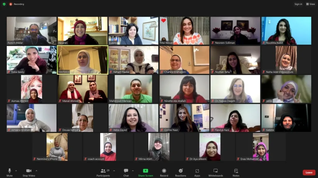 A Zoom video call with 25 participants, most smiling and looking at their cameras, each in individual windows. Various...